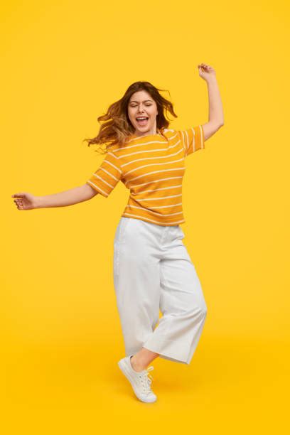 Woman smiling in yellow top and denim shorts